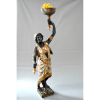 BLACKAMOOR VENEZIANO<br />Escultura em madeira talhada, carnada e policromada.<br />Folhas de ouro. Bandeja numa mão, e tocha na destra.<br /><br />Medidas: 230 x 70 x 36cm. Só a base oitavada: 45 cm. <br /><br />REFERÊNCIAS: Imensamente popular do século 16 ao 19, o estilo “BLACKAMOOR” apresentava figuras africanas estilizadas e era comum em esculturas, joias e móveis. <br />Pintadas em esmalte preto brilhante e enfeitadas com trajes de penas coloridas, teriam funcionado como uma forma palatável de exotismo para seus proprietários europeus brancos, imitando os servos e escravos negros vestidos de forma teatral que faziam parte das casas nobres europeias. No entanto, essas figuras negras primorosamente modeladas também foram lidas como uma homenagem ao triunfo colonial da Europa. Essas estatuetas de porcelana muitas vezes continham tigelas de açúcar, dado o uso de mão-de-obra escrava negra nas plantações de açúcar dos primeiros europeus modernos. <br />Derivado da palavra latina “Maurus”, o termo foi originalmente usado para descrever os berberes e outras pessoas da antiga província romana da Mauritânia, onde hoje é o Norte da África. Com o tempo, foi cada vez mais aplicado aos muçulmanos que viviam na Europa. A partir da Renascença, “mouro” e “BLACKAMOOR” também eram usados para descrever qualquer pessoa de pele escura.<br /><br />