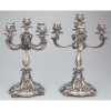 Par de candelabros de prata do Porto prensada e fundida, decorada com figurações barrocas, com quatro braços, para cinco velas, base recortada sobre quatro conchas.- 38 cm de altura.- Portugal, séc. XX, - posterior a 1938.