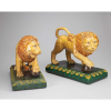 Par de leões de faiança vidrada e a cores, ambos com as patas dianteiras sobre esfera, base retangular verde. 37 x 19 x 30 cm de altura. - China, séc. XX.