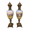 <p>Imponente e raro par de ânforas em porcelana azul-cobalto, com reservas representando Napoleão a cavalo em campo de batalha, ambas identificadas pelas batalhas de Eylau (ou Batalha de Preussisch Eylau, ocorrida em 7 de fevereiro de 1807) e Jena-Auerstedt (ocorrida em 14 de outubro de 1806). Parte superior monogramada com o N Imperial, ornamentada por fino bronze. Marca na tampa da Manufatura Imperial de Sèvres. França, séc. XIX. 134 cm de alt. (Uma tampa está restaurada)</p>