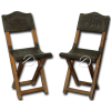 Par de cadeiras tesoura, de madeira, dobráveis com encosto e assento de couro lavrado; pernas retas e cruzadas fixadas por travas; 86 cm de altura. Brasil, sec. XIX.