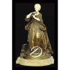 G. Abell. Madame Du Barry. Escultura de bronze patinado e marfim, apresentando-se de pé segurando ramo de flores, base circular de ônix, identificada na frente da base e assinada atrás, G Abell; 68 cm de altura. França, séc. XIX. Acompanha mesa circular de madeira trabalhada com douração, e tampo de mármore branco, quatro pernas recurvas trabalhadas e trave cruzada; 70 cm de altura e 55 cm de diâmetro. 