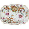 Travessa de porcelana Companhia-das-Índias, padrão folha de chá, corpo retangular, aba delimitada por borda recortada e friso com filetes vermelhos, decoração com ramos flores e círculos em policromia; 25,5 x 18,5 cm. China, séc. XVIII. Apresenta colagem a faca, pequenos bicados e trincado. 