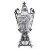 Grande samovar de prata francesa fundida, repuxada e cinzelada, no estilo Napoleão III, profusamente ornado em relevos; corpo decorado com cena mitológica, elementos fitomórficos e cabeças de caprinos com corpos recurvos terminados em patas, encimando base recortada de contornos irregulares com inscrição do fabricante em seu reverso, Odiot - Paris; torneira com folhas de acanto e flores; puxador da tampa, floral. Na faixa lisa sobre o bojo, na borda do interior da tampa, marcas de identificação da prata cabeça de minerva 1, de importação e garantia de toque 0,916, javali I e do importador Part.; 60,5 cm de altura total. França, séc. XIX.