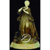 G. Abell - Madame Du Barry. Escultura de bronze patinado e marfim, apresentando-se de pé segurando ramo de flores, base circular de ônix, identificada na frente da base e assinada atrás, G Abell; 68 cm de altura. França, séc. XIX. - Acompanha mesa circular de madeira trabalhada com douração, e tampo de mármore branco, quatro pernas recurvas trabalhadas e trave cruzada; 70 cm de altura e 55 cm de diâmetro.