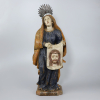 <p>Santa Verônica. Imagem de madeira entalhada e policromada representando a santa de pé, com rosto pulcro, olhar misericordioso, longo véu e vestes movimentadas, características do Barroco Brasileiro, sustentando com ambas as mãos seu véu, com expressivo rosto de Cristo esculpido em relevos, com o qual enxugou o rosto Dele. O todo sobre base retangular de cantos chanfrados; 77de altura total com resplendor de prata, com pedra colorida, de 9de altura. Brasil, séc. XVIII.</p>