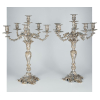 Monumental par de candelabros em prata de lei repuxada e cinzelada - corpo em formato de balaústre encimado por cinco braços e um fuste central sobre base circular com três pés - rica decoração com motivos vegetais - na base marcas Sterling e Howard & Co., NY 1900 - altura, 67 cm - Estados Unidos, C. 1900